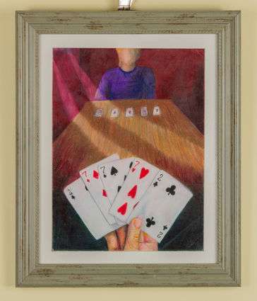 person holding cards facing another person at the end of the table