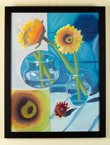 has two big flowers in glass and one small red flower on light blue table 